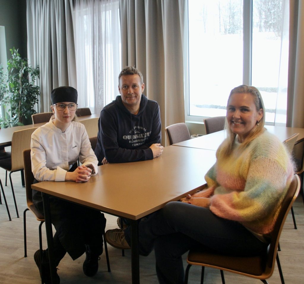 Tre personer rundt et bord